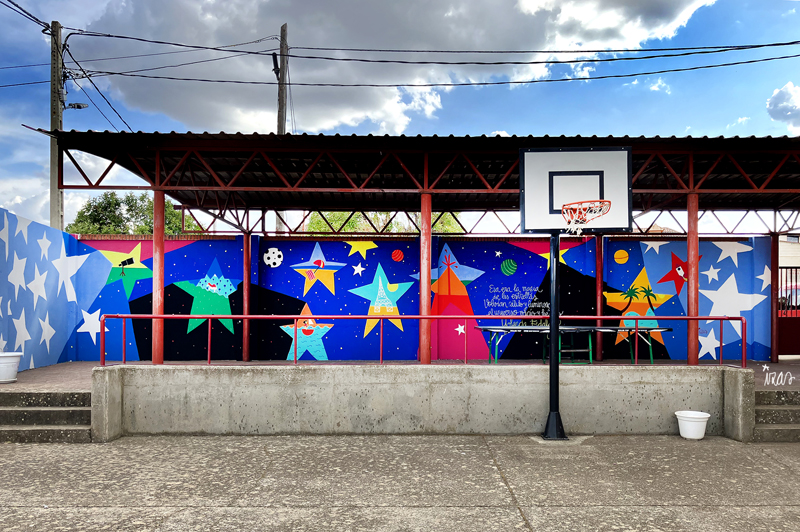 mural izas azulpatio dibujando la palabra CRA Tábara pano 1